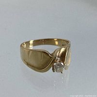 Oblique front view showing the oval diamond set between two architectural oval shoulders