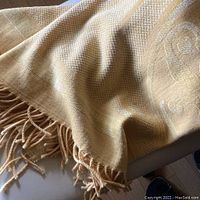 Lemon butter colored soft throw blanket with fringed edge showing texture and color.