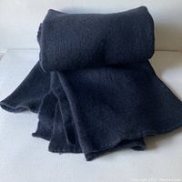 Full view of the vintage wool blanket, rolled and partially spread showing the midnight blue overdyed solid color and texture.