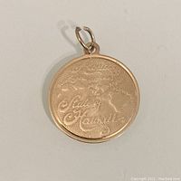 Front side of the circular gold charm showing the Hawaiian Islands map and 'Aloha Sweet Hawaii' text in engraved script.