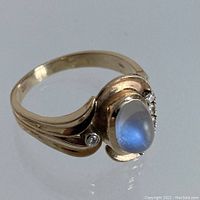 Angled view showing swirling grooved band and side accent diamond