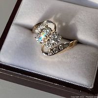Ring in presentation box showing top view of diamond and gold design