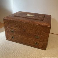 Chest closed front angled view showing quarter-sawn oak grain and brass hardware