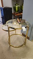 Full view of assembled brass and glass side table with wooden legs stored on top