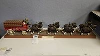 Full view of the Budweiser Clydesdales figurine team pulling the wagon on wood base.