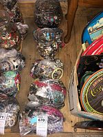 Overview photo showing six containers filled with assorted costume jewelry including beads, chains, and various pendants.