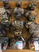 Overview photo showing six containers filled with assorted costume jewelry like necklaces, bracelets and earrings in various colors and materials.
