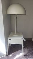 Full view of white mushroom lamp placed on white metal side table with drawer, showing overall appearance and condition.