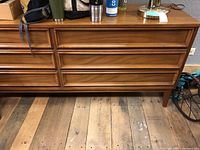Full front view of dresser showing six drawers and medium brown finish.