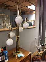 Full view of brass waterfall floor lamp with five white opal glass globes