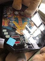 Top-down view of playfield under glass showing flippers, bumpers, and slingshots