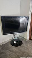 Sony Bravia television on glass TV stand showing front full view