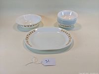 Full set displayed: 1 platter, 1 serving bowl, 9 cereal bowls, all white with golden butterfly border design.