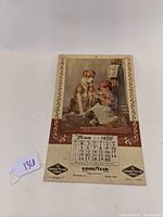 Full view of 1950 Goodyear Tire dealer's wall calendar with 'Fifty Fifty' illustration of boy and dog sharing ice cream cone.