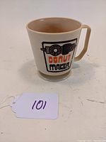 Tan melamine coffee mug featuring a retro "Donut Maker" graphic in black and orange, showing the front and side with the squared handle.