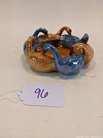 Side view of the circular dish showing the brown and blue glossy geese forming a ring