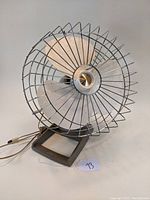 Full front angle view of the mid century Kenmore electric desk fan showing metal blades and wire cage.