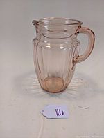 Front angle view of the pink depression glass pitcher showing pillar optic vertical ribbing and handle.