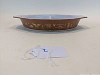 Side view showing brown rim with gold kitchen and vegetable motifs in Early American pattern.