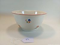Front and side view of the vintage Homer Laughlin mixing bowl showing floral decoration and red rim.