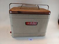 Full front side view of the vintage Therm-a-Chest cooler showing the metal body, lid, handle and the logo on the front.