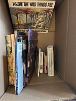 Image showing 'Where The Wild Things Are' and various children's books arranged upright in a box.