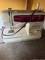 Front and side view of Baby Lock B17 sewing machine showing control knobs, threading mechanism, and power cord.