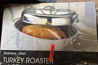 Box showing a stainless steel turkey roaster with a cooked turkey inside and matching lid on top.