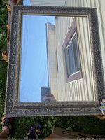 Full view of rectangular vintage mirror showing ornate frame and reflection.