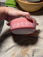 Side view of the pink Pyrex casserole dish with white gooseberry floral design.