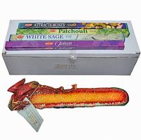 Photo showing the dragon-shaped resin stick incense burner next to a white box and three boxes of HEM incense sticks.