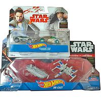 Photo showing Hot Wheels Star Wars Character Cars with Rey and Luke Skywalker, and the Hot Wheels Star Wars die-cast set with First Order Transporter and Resistance X-Wing Fighter in original packaging.