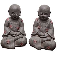 Pair of grey baby Buddha statues with pink flowers shown side-by-side