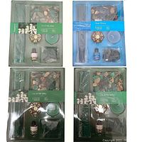 Four boxed incense kits arranged with three Lily of the Valley (green boxes) and one Ocean Breeze (blue box). Visible incense sticks, cones, decorative burner, tealight candle, aroma oil bottle, and potpourri inside each sealed box.