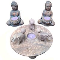 Set of two Buddha tealight holder statues and one circular elephant-themed tealight holder arranged on white background