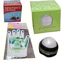 Four items displayed: Newton's Cradle desktop accessory in box, Reflexology gloves showing pressure points in sealed pack, selenite candle holder in box, and hand massager.