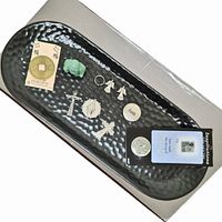 Photo showing a top-down view of a black ceramic plate holding the listed spiritual and jewelry items neatly arranged.