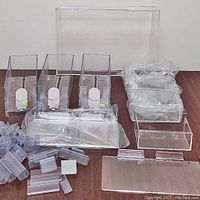 Lot contents showing assortment of clear acrylic retail display boxes, label holders, and shelves.
