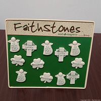 Green metal display stand with 10 cream resin magnets arranged and mounted, showing Celtic crosses, angels and shamrocks with blessings inscriptions.