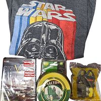 Front view of Star Wars grey t-shirt with Darth Vader graphic, sealed Civilization V PC game, John Deere coasters, and McDonald's Black Panther toy.