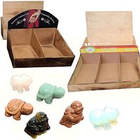 Photo showing four wooden boxes arranged in the back with six semi-precious stone figurines - elephants, turtles, and Buddhas - arranged in front.