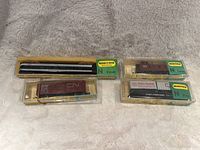 Four N scale Minitrix CN Railway model trains in original boxes displayed on a blanket.