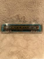 Side view of the N scale Canadian National observation car in original clear plastic case showing detailed paint and lettering.