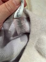 Close-up photo of Calvin Klein tag and fabric care label inside the light-colored hat.
