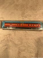 Photo of Southern Pacific N Class model train carriage in original box showing orange and red livery with black text.