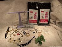 Photo of all jewelry, hanging purse organizers, and jewelry stand laid out on beige fabric background.