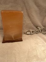 Square salt lamp standing on a beige surface with USB power cord visible to the right.