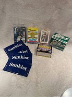Photo showing multiple unopened sports card packs including Sunkist blue packs, hockey card pack with Maslund, 1987 Major League Baseball's Best pack, and other baseball card boxes.