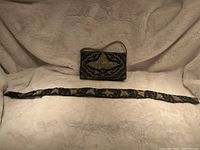 Photo of the full set showing the rectangular hand beaded purse with flap and the matching hand beaded belt laid out flat.