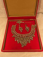 Full set of wedding jewelry including necklace, earrings, bracelet, and ring, displayed in red jewelry box with tan interior.